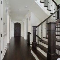 Foyer in new construction home with dark wood staircase